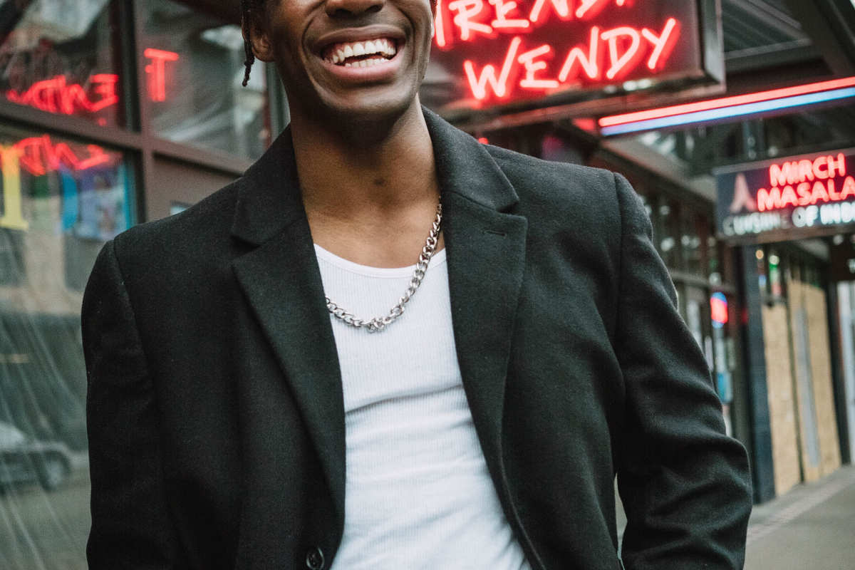 Smiling man wearing a black jacket and white t-shirt