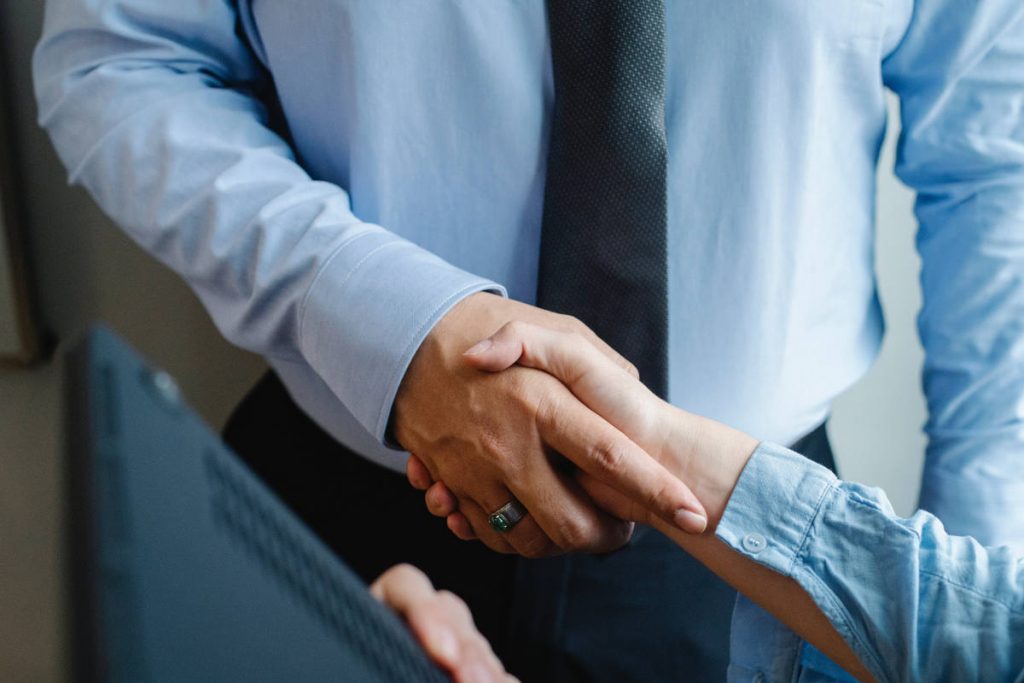 POV shot shaking hands with a man wearing a tie