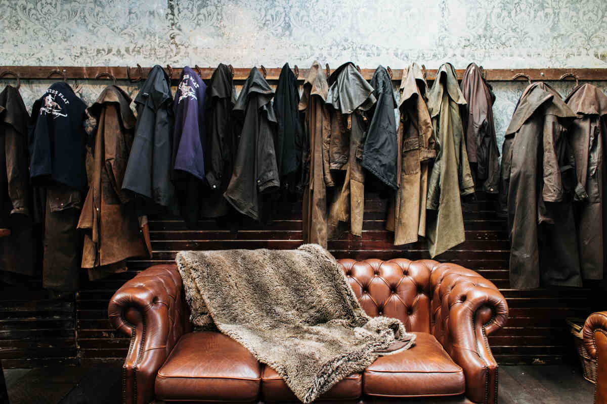 Wall hanger with a row of old leather jackets and a vintage couch in front