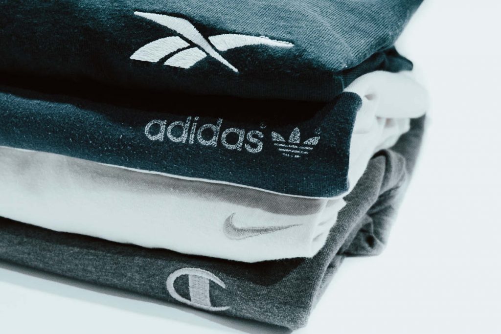 Stack of folded branded t-shirts lying on a white surface
