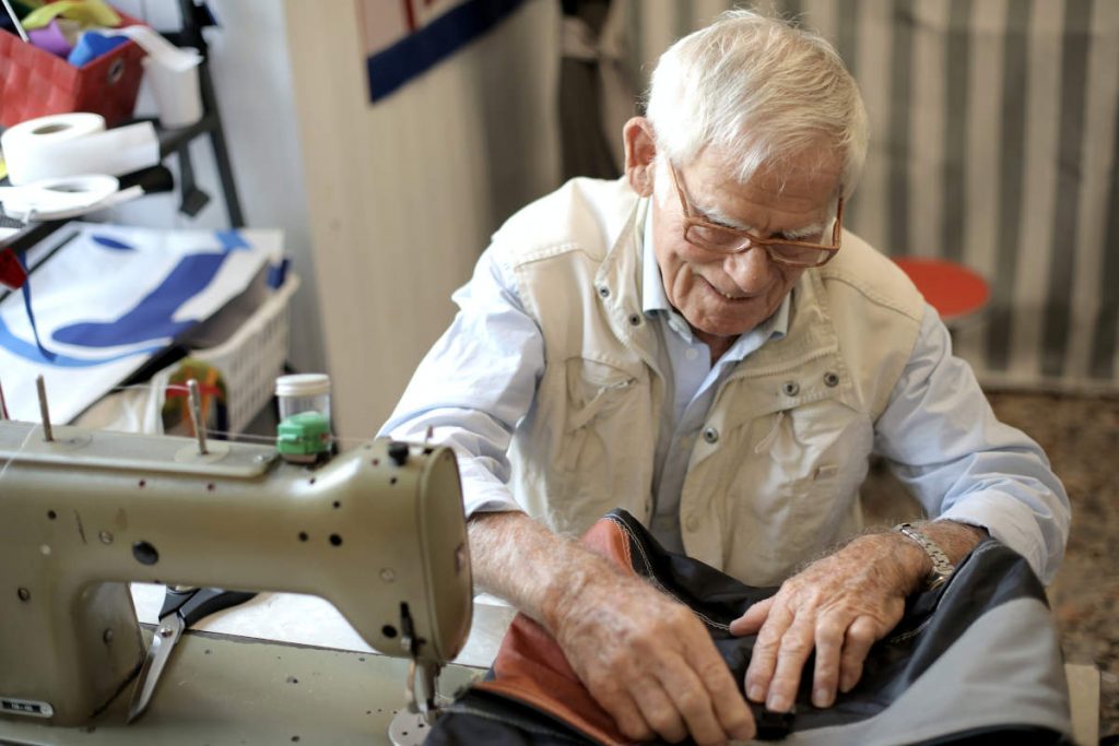 Elderly tailor working on a sewing machine