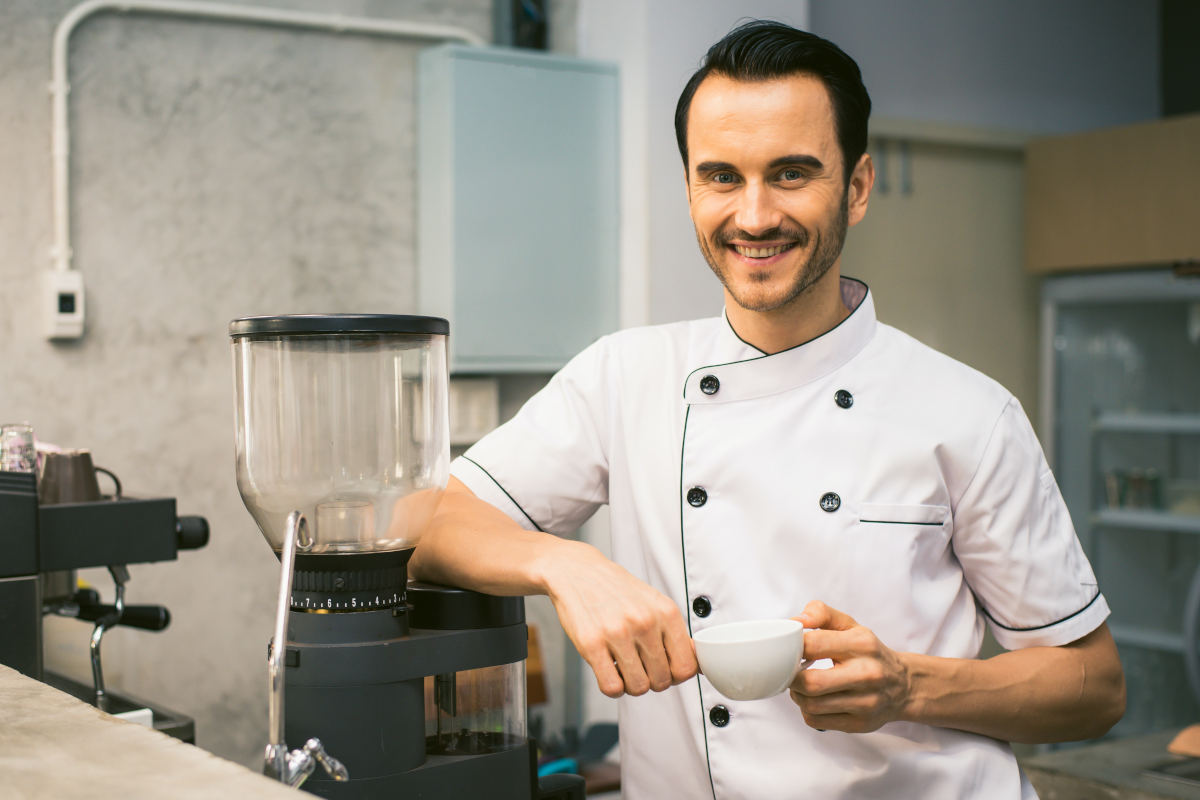 Young professional cook posing in front of a stand